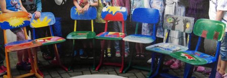 Die Kinder präsentieren ihre bemalten Stühle.